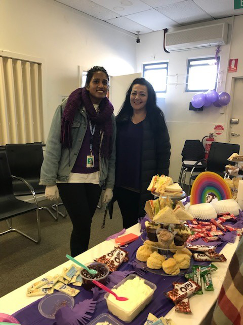 Two women standing in front of a table filled with party food.